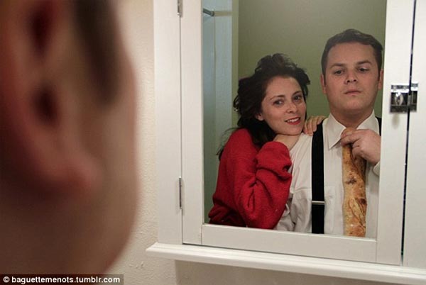 Dan Gregor & Rachel Bloom pose in a mirror while adjusting a loaf in supplement of his tie