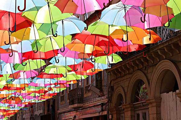 Shower of colour! Artist creates illusion of floating umbrellas in vivid art installation