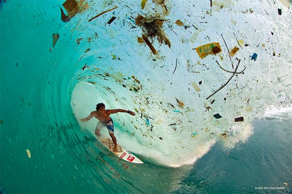 Surfer Gliding Through Trash-Filled Wave