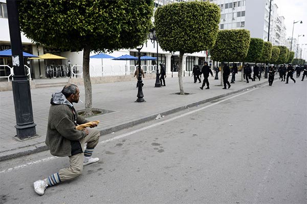 Tunisian man holds back riot police with a baguette