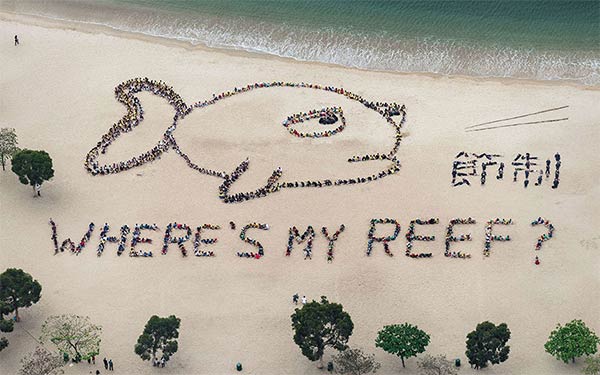 Kids Forming Giant Reef Fish On Beach